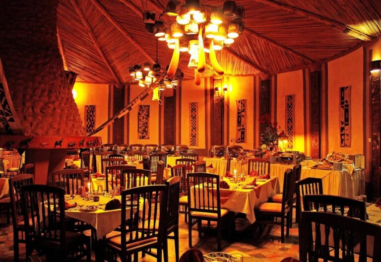 La sala del ristorante la sera, con tovaglie gialle e lampadari accesi