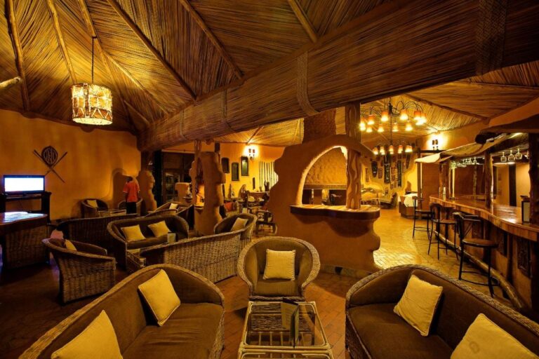 Il salone e il bar, con poltrone di rattan dai cuscini gialli e sgabelli al bancone