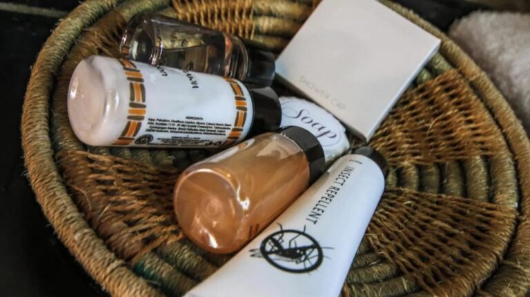 Un cestino intrecciato pieno di prodotti di cortesia, tra cui un repellente per insetti