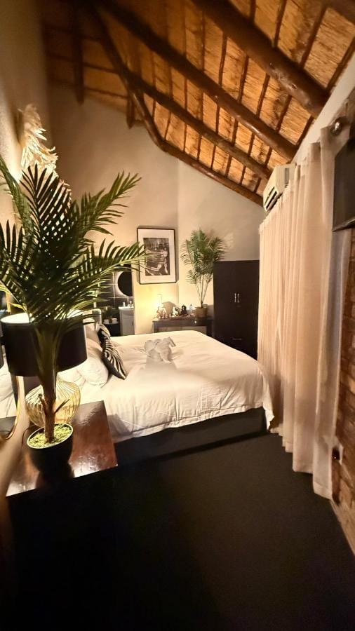 Una camera sotto la paglia, con un letto matrimoniale, un armadio scuro e tende leggere davanti alla finestra
