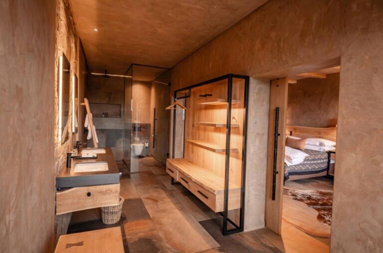 Il bagno di una suite, con doccia in vetro, lavabo e guardaroba aperto