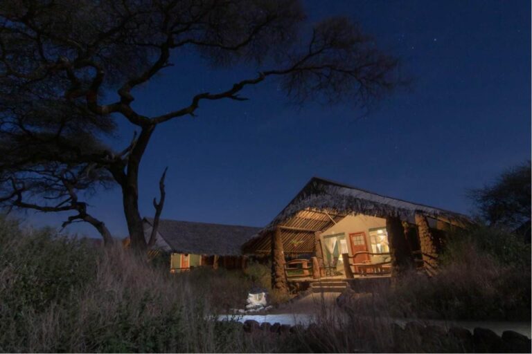 Una tenda sotto il suo tetto di paglia, illuminata di notte sotto un cielo stellato