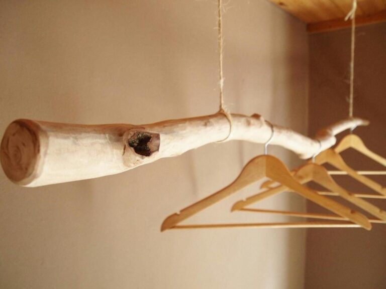 Grucce di legno appese a un ramo scortecciato, sospeso al soffitto con delle corde
