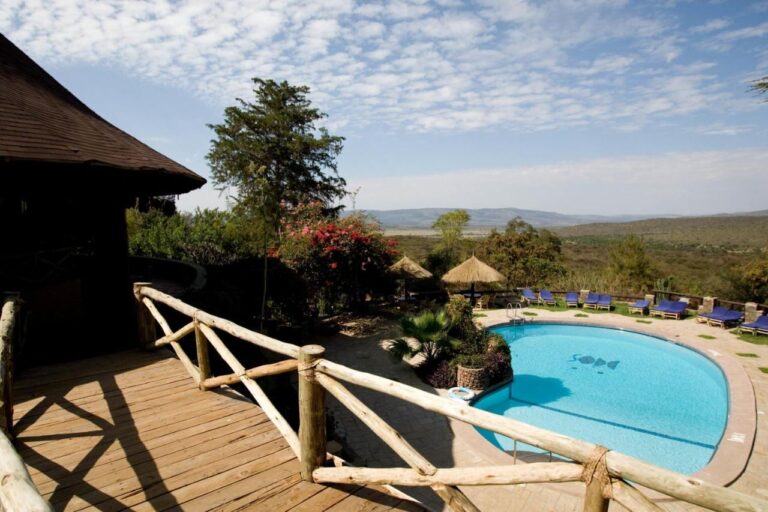 La piscina del Mara Sopa Lodge vista da una terrazza in legno, davanti alla boscaglia e alle colline