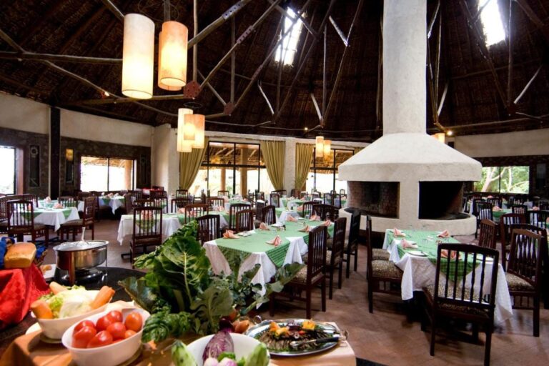 Il ristorante, con i tavoli dalle tovaglie verdi e un buffet di verdure in primo piano