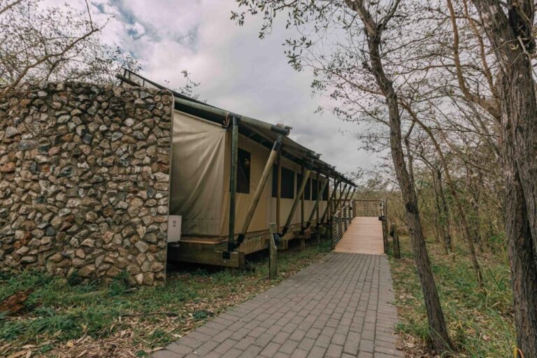 Una tenda del lodge, metà pietra e metà tela, in fondo a un vialetto lastricato