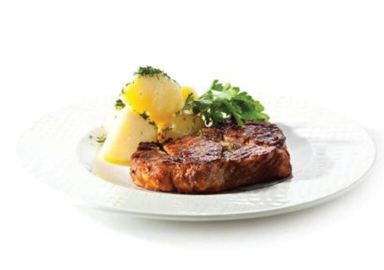 Un taglio di carne alla griglia con patate ed erbe aromatiche