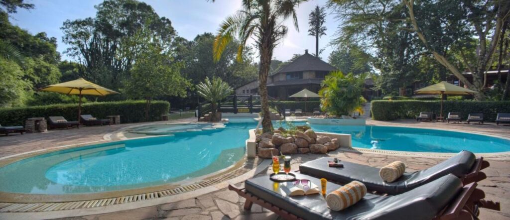 La piscina a forma di laguna del Sarova Mara Game Camp, intorno a un isolotto di rocce con una palma