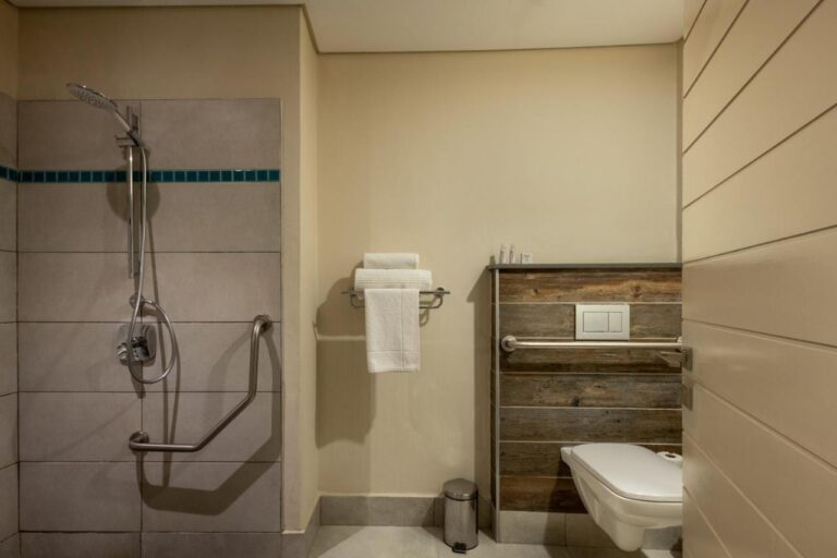 Un bagno con doccia a filo pavimento, maniglioni e WC sospeso