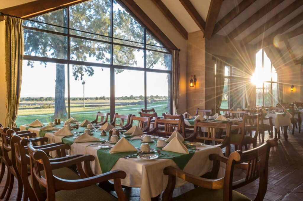 Il ristorante dello Sweetwaters Serena Camp, con i tavoli apparecchiati davanti a una grande vetrata sulla pianura