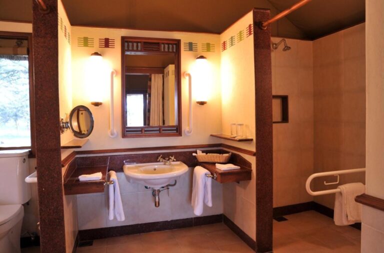 Un bagno accessibile, con maniglioni, lavabo e doccia a filo pavimento