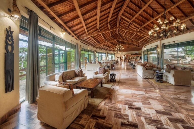 Il grande salone del lodge, con le poltrone e le vetrate sotto una travatura in legno