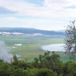 Il fondo verde del cratere visto dal bordo, con il lago Magadi e le nuvole aggrappate alle pareti